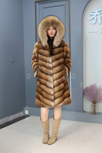 Load image into Gallery viewer, Full length muskrat fur hooded coat with racoon trim